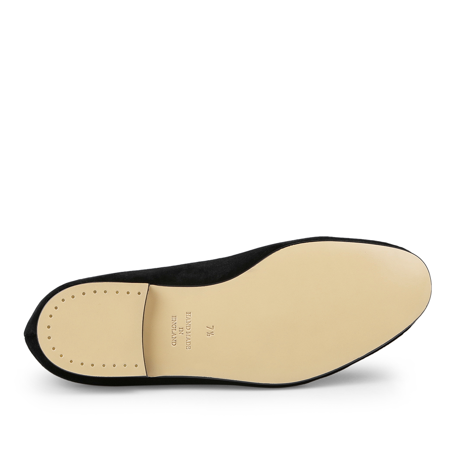 The Plain Black Velvet Albert Slippers by Bowhill Elliott feature a durable beige leather sole, embossed text, and a row of small dots near the heel.