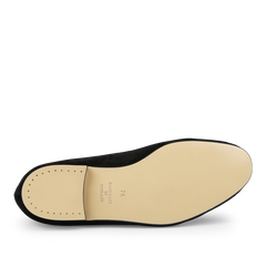 The Plain Black Velvet Albert Slippers by Bowhill Elliott feature a durable beige leather sole, embossed text, and a row of small dots near the heel.