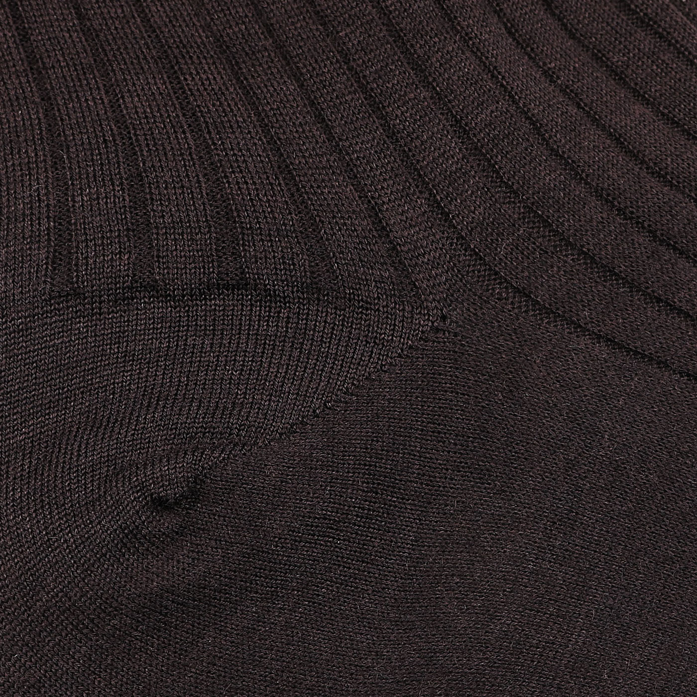 Close-up of dark brown ribbed fabric with a diagonal seam pattern, reminiscent of Bresciani's fine wool nylon socks, crafted in Italy.