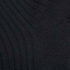 A close up of a black sweater with ribbed cuffs and Bresciani navy blue ribbed wool nylon socks.