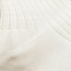 Close-up of a cream-colored ribbed fabric with diagonal stitching details, similar to the Off White Ribbed Wool Nylon Socks by Bresciani that are crafted in Italy.