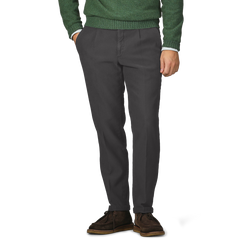 A person wearing a green sweater and Briglia's Dark Grey Cotton Twill BG21 Pleated Trousers, hands in pockets, with brown shoes visible.