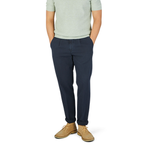 A man wearing a green t-shirt and Navy Blue Cotton Linen BG59 Pleated Chinos made from an upcycled mix of cotton and linen by Briglia.