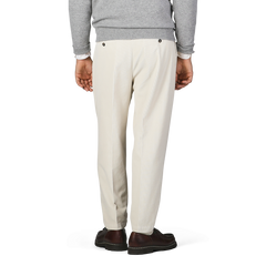 Rear view of a person wearing a gray sweater, Off White Corduroy Courmayeur Trousers by Briglia, and brown shoes, standing against a plain background.