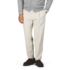 A person wearing a grey sweater with Briglia's Off-White Corduroy Courmayeur Trousers and brown shoes stands with one hand in the pocket.