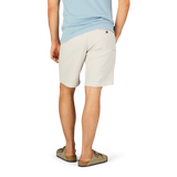 Man standing in Briglia's stone beige cotton-linen mix pleated shorts and casual footwear against a plain background.