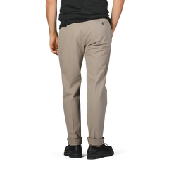 A man is seen from the back wearing black shoes, a black shirt, and Briglia's Taupe Beige Cotton Stretch Soho Trousers. These regular fit cotton twill trousers feature a single back pocket with a button.