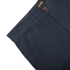 Close-up of Blue Double Twisted Cotton Twill Fatigue Pants by C.O.F Studio, showcasing navy blue color in durable cotton twill with side pockets, a brown button, and a label inside the waistband.