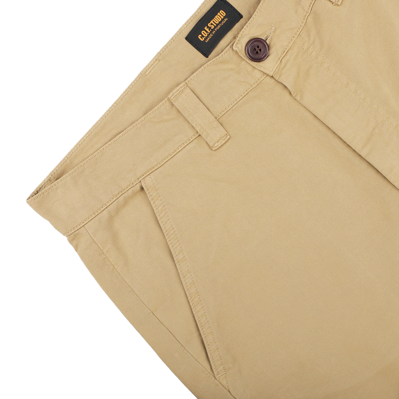 A close-up of Khaki Double Twisted Cotton Twill Fatigue Pants features a buttoned waistband and displays the C.O.F Studio brand label on the inside. Made from recycled fibers, the fabric looks smooth and well-tailored.