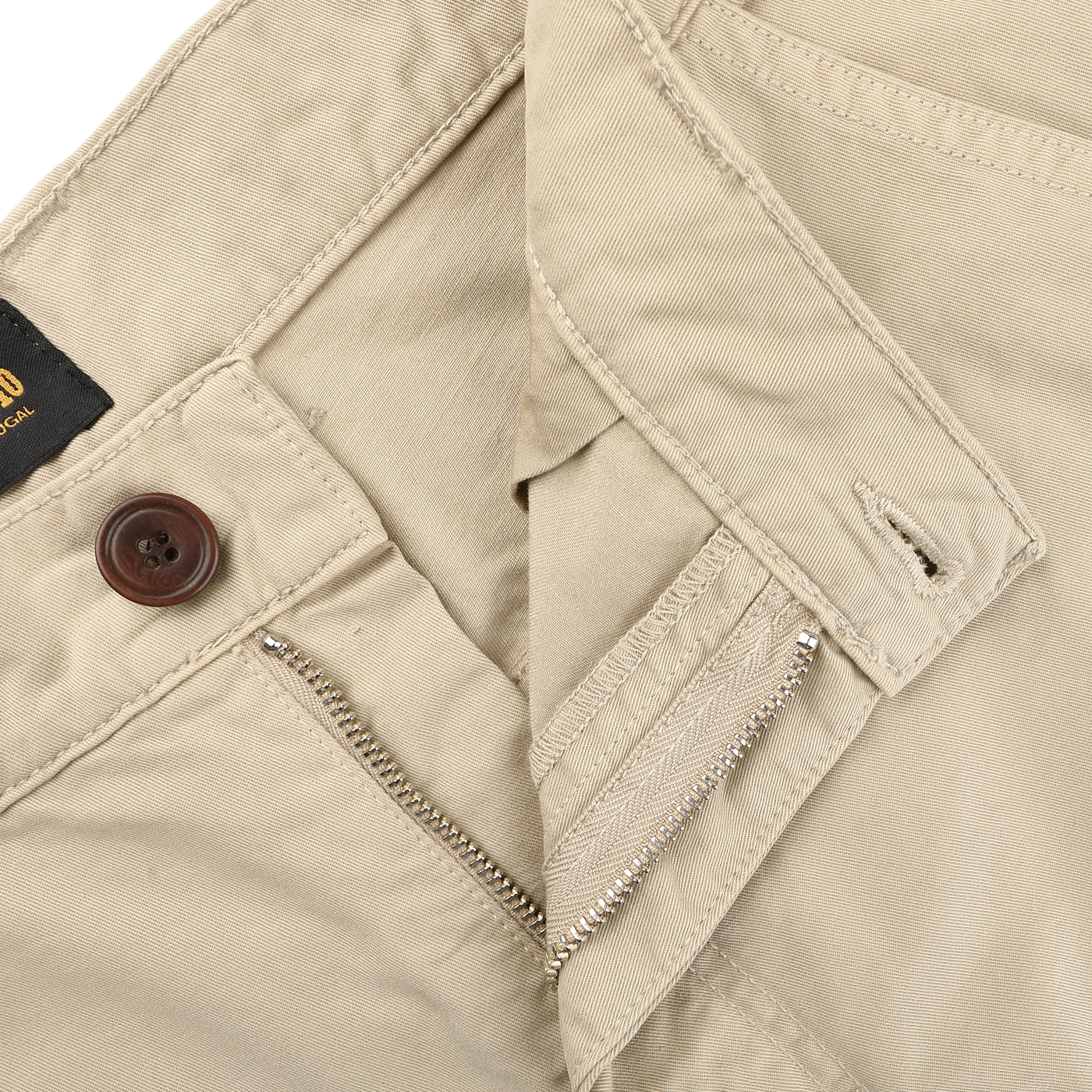 Close-up of C.O.F Studio's Sand Double Twisted Cotton Twill Fatigue Pants made from recycled fibers, showcasing a brown button, partially open zipper, belt loops, and stitching detail.