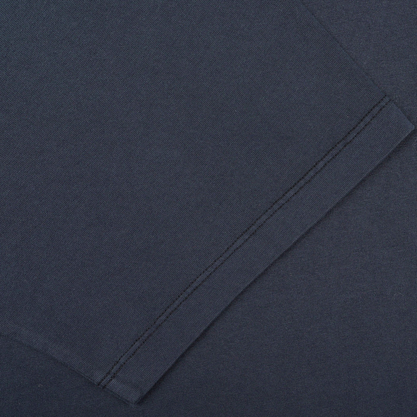 Close-up of a neatly stitched sleeve hem on the C.O.F Studio Navy Blue Organic Cotton Crewneck T-Shirt. The fabric appears smooth and uniformly colored, reflecting the quality of this regular fit garment.