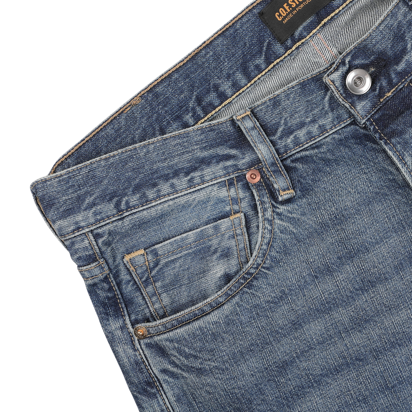 Close-up of the upper section of Washed Blue 14oz Kuroki Selvedge Cotton M8 Jeans by C.O.F Studio, featuring a front pocket, a small coin pocket, a metal button, and belt loops. The jeans have a faded, worn look with visible stitching details that highlight their premium craftsmanship.