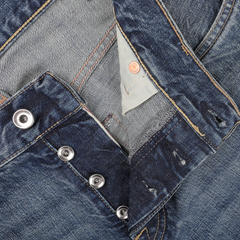 Close-up of Washed Blue 14oz Kuroki Selvedge Cotton M8 Jeans with the button fly partially open, revealing the inner fabric and metal buttons from C.O.F Studio's collection.