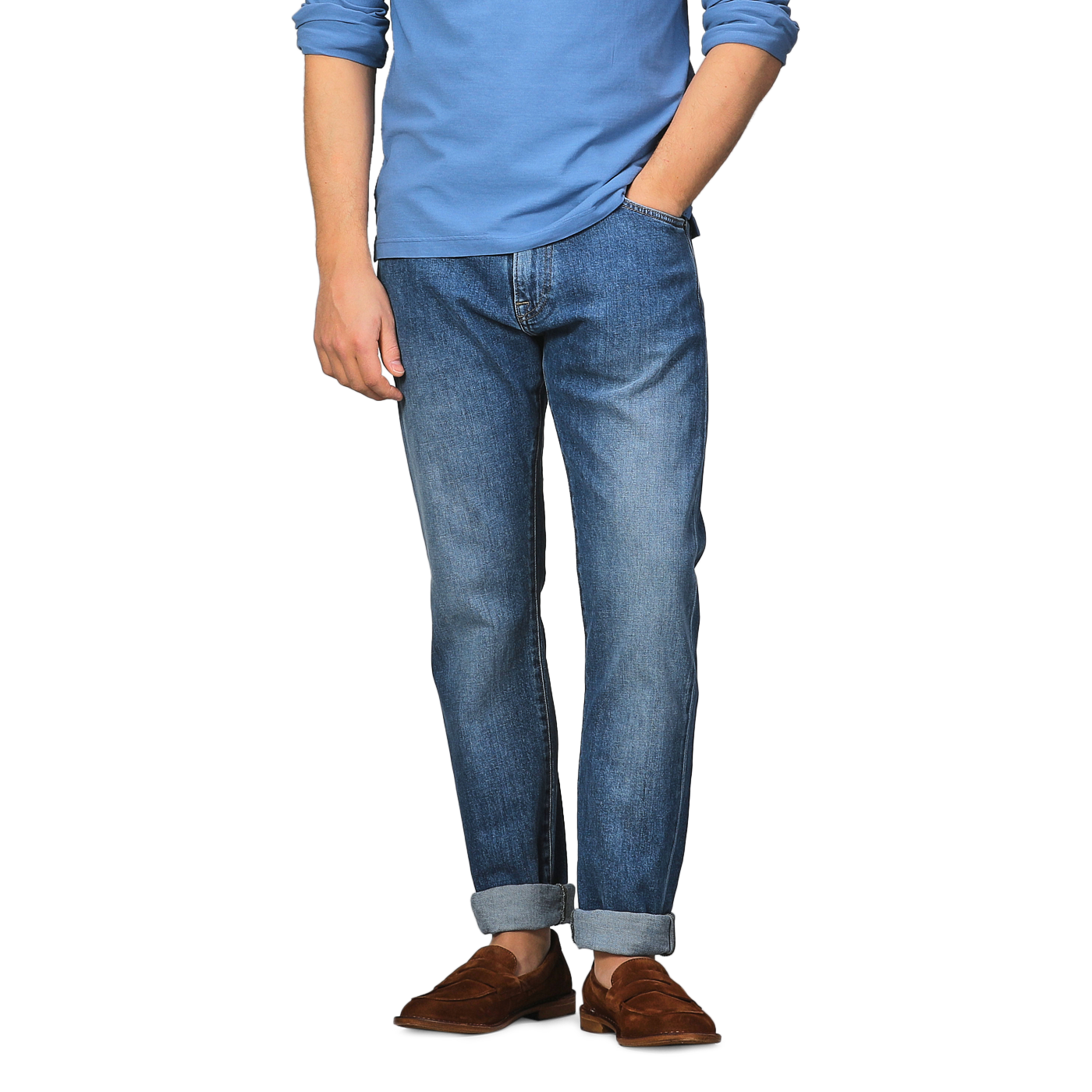 A person in a blue long-sleeve shirt, C.O.F Studio Indigo Blue Washed Organic Cotton M8 Jeans with cuffs, and brown loafers stands against a plain background.