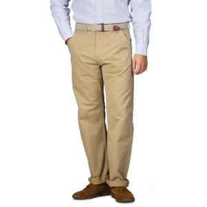 A person wearing a striped shirt, Khaki Double Twisted Cotton Twill Fatigue Pants from C.O.F Studio, and brown shoes is standing. The fatigue pants are secured with a textured belt.