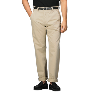 A person wearing C.O.F Studio's Sand Double Twisted Cotton Twill Fatigue Pants, accented with a black belt and shoes, stands with hands in pockets against a plain background.