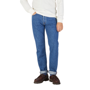 A man wearing C.O.F Studio Blue Organic Candiani Cotton M6 6x Wash Jeans and a white sweater.
