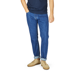 Man wearing C.O.F Studio Blue Organic Kurioki Cotton M7 6x Wash Jeans and beige shoes, cropped at chest level against a white background.