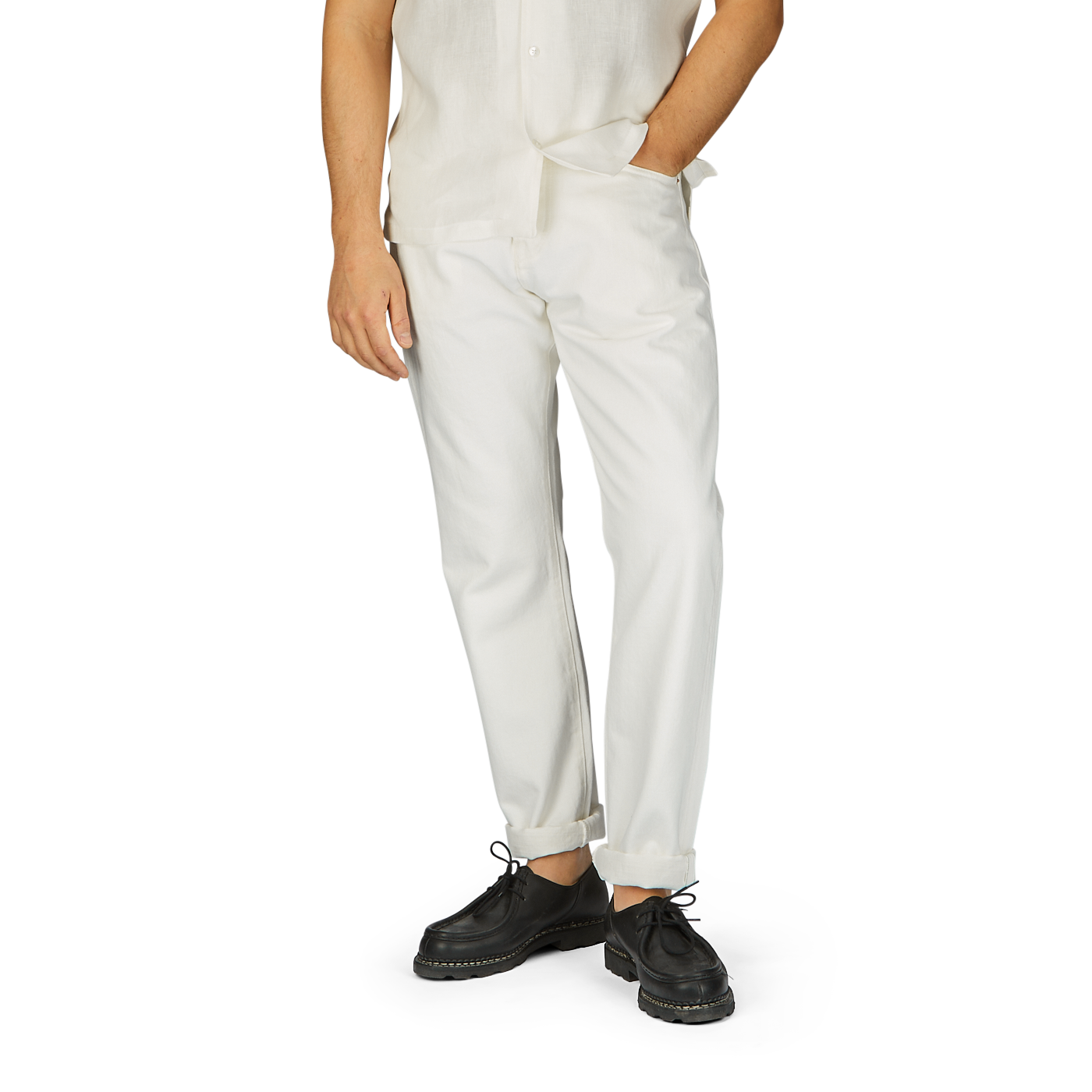 Man wearing a white shirt and Ecru Stone Washed Kuroki Cotton M5 Jeans by C.O.F Studio with dark shoes, standing against a plain background, cropped at the waist.