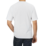 Person wearing a C.O.F Studio White Organic Cotton Crewneck T-Shirt and blue jeans, seen from behind.