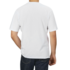 Person wearing a C.O.F Studio White Organic Cotton Crewneck T-Shirt and blue jeans, seen from behind.