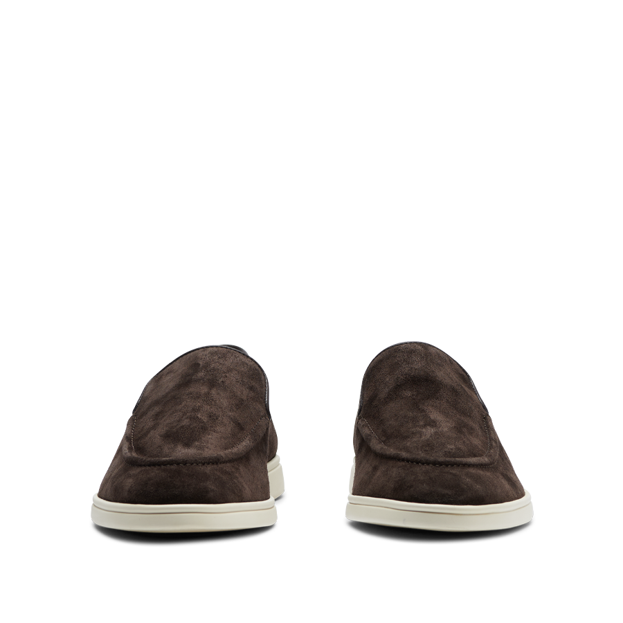 A pair of Chocolate Brown Suede Leather Debonair Slippers with white rubber soles on a striped gray background by CQP.