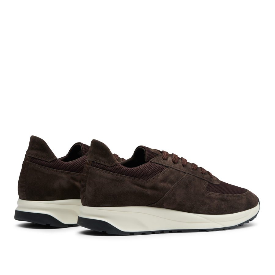 A pair of CQP dark brown suede leather Stride runners with white soles, displayed against a transparent background.