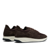 A pair of CQP dark brown suede leather Stride runners with white soles, displayed against a transparent background.