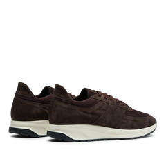 A pair of CQP dark brown suede leather Stride runners with white soles, displayed against a transparent background.