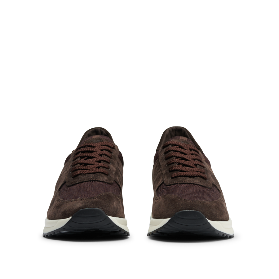 A pair of dark brown suede leather CQP Stride Runners with dark laces and white soles, viewed from the front.