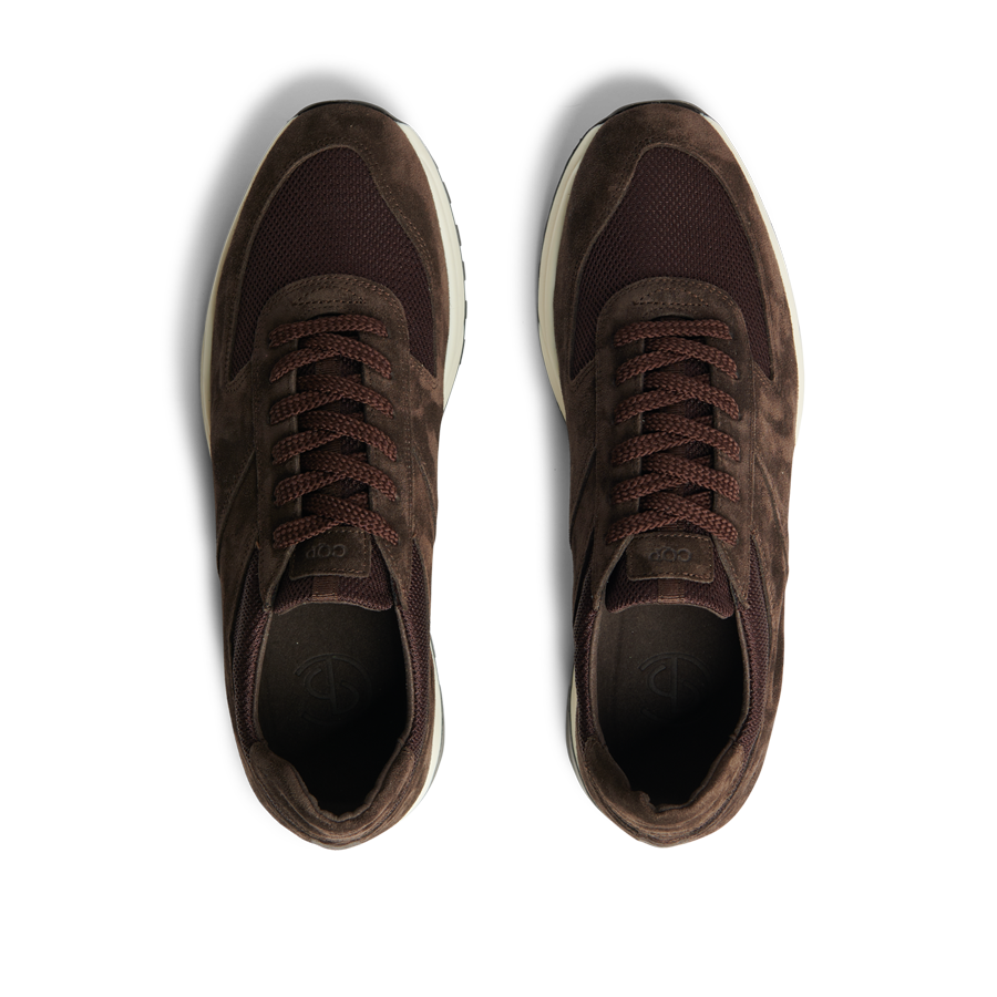 A pair of CQP Dark Brown Suede Leather Stride Runners with dark laces, viewed from above on a transparent background.