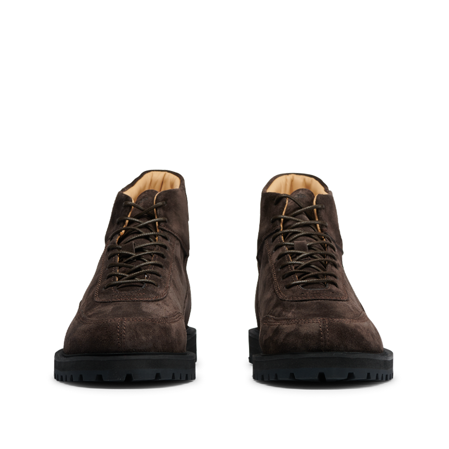 A pair of CQP Dark Brown Suede Leather Sabulo Boots with thick black soles, shown from a front-facing angle on a transparent background.