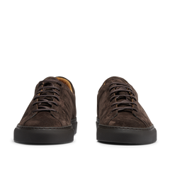 The CQP Ebony Brown Racquet Sr sneakers, made from dark brown suede calf leather with black outsoles, are viewed from the front and provide improved arch support for exceptional comfort.