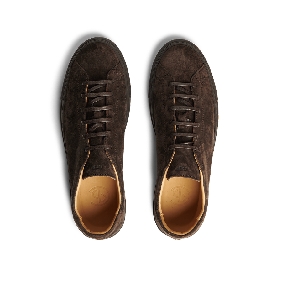 Top view of a pair of Ebony Brown Racquet Sr suede calf leather sneakers by CQP, featuring laces, a light brown inner lining, a black sole, and enhanced arch support.