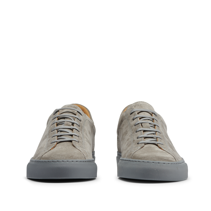 Front view of a pair of CQP Granit Grey Suede Leather Racquet Sr sneakers with white laces on a transparent background.