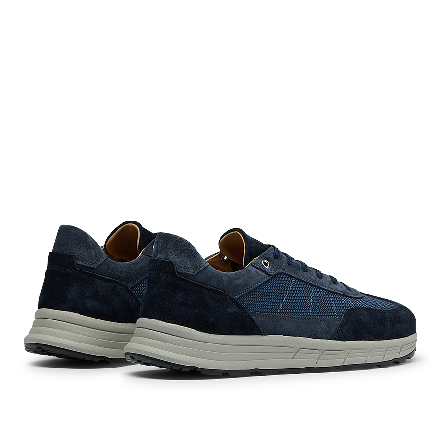 A side-angle view of a pair of Navy Suede Leather Renna Mesh Sneakers by CQP, featuring white VIBRAM soles and a combination of mesh and suede textures.