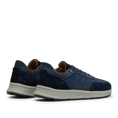 A side-angle view of a pair of Navy Suede Leather Renna Mesh Sneakers by CQP, featuring white VIBRAM soles and a combination of mesh and suede textures.