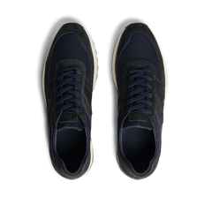 A pair of new, Obsidian Blue Suede Leather Stride Runners with laces on a striped black and white background by CQP.