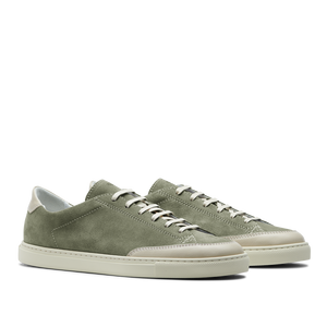 The Olive Green Suede Leather Bumper Sneakers by CQP capture the retro tennis shoe aesthetic with crisp white laces and durable white rubber soles for a classic yet stylish look.