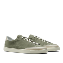 The Olive Green Suede Leather Bumper Sneakers by CQP capture the retro tennis shoe aesthetic with crisp white laces and durable white rubber soles for a classic yet stylish look.