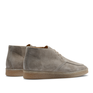 A pair of Taupe Beige suede leather Plana boots with crepe soles and laces, viewed from the side, against a transparent background.