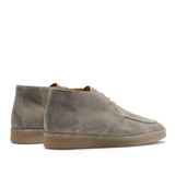 A pair of Taupe Beige suede leather Plana boots with crepe soles and laces, viewed from the side, against a transparent background.
