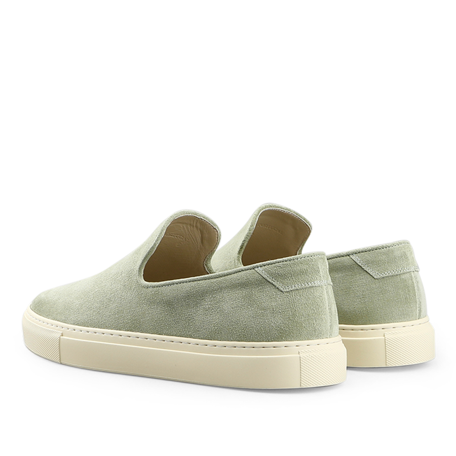 The back view displays the Sage Green Textured Suede Jetty Wholecut Slip-On shoes by CQP, featuring sleek design and supportive rubber soles.