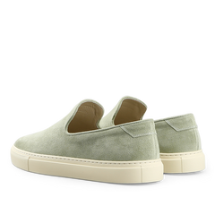 The back view displays the Sage Green Textured Suede Jetty Wholecut Slip-On shoes by CQP, featuring sleek design and supportive rubber soles.