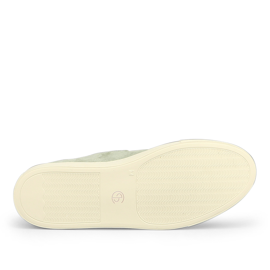 The image showcases the bottom of a Sage Green Textured Suede Jetty Wholecut Slip-On by CQP, featuring a supportive textured rubber sole with a small logo near the center for enhanced comfort.