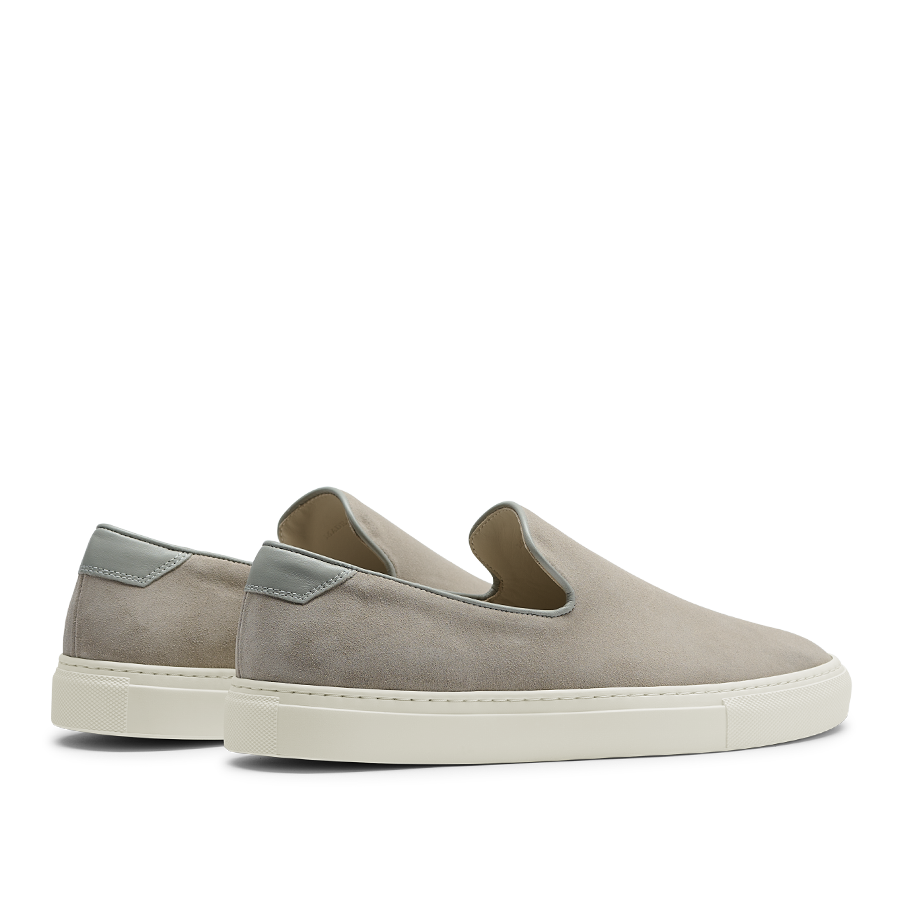 A pair of Sand Suede Leather Jetty Wholecut Slip-on sneakers with white soles and light grey accents on the heel, handmade in Portugal by CQP.
