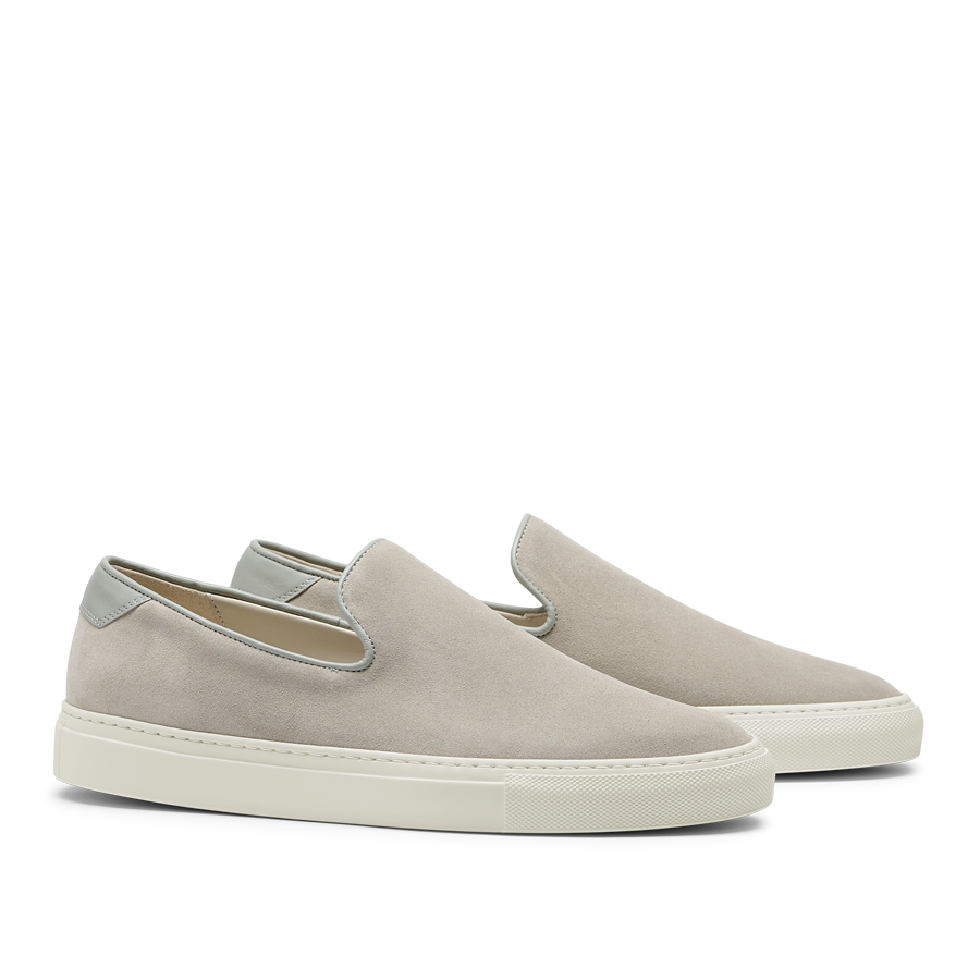 A pair of Sand Suede Leather Jetty Wholecut Slip-on sneakers with white soles on a transparent background, handmade in Portugal by CQP.