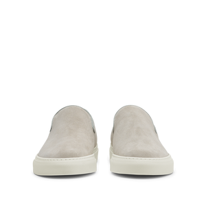 A pair of Sand Suede Leather Jetty Wholecut Slip-on shoes with white rubber soles, handmade in Portugal by CQP, displayed on a translucent background.