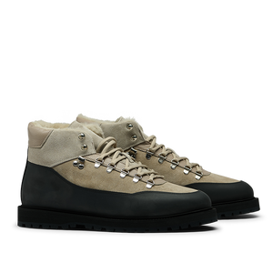 The Taupe Suede Fur Lined Saxum Terrain Boots by CQP are a pair of beige and black hiking boots with laces and metal eyelets, featuring a textured sole, water-repellant suede, and a wool fur-lined interior.