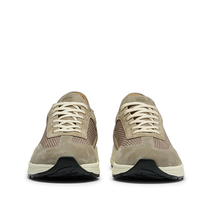 A pair of taupe suede leather Renna mesh sneakers by CQP with white laces and black VIBRAM outsoles, crafted from premium materials, displayed front-facing on a white background.